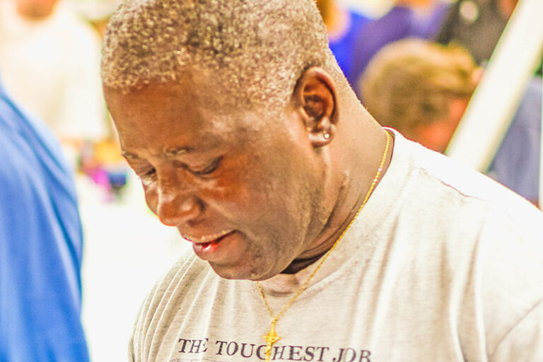 Raeford standing inside with white shirt and name tag